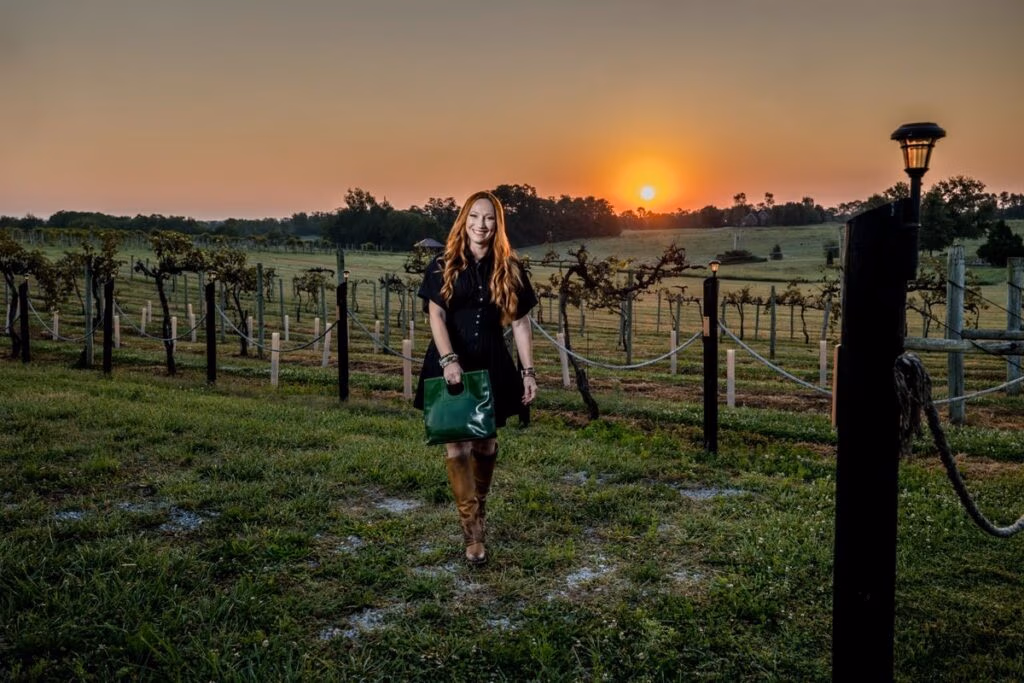 Michelle Michael-Friedel walking through a vineyard at sunset